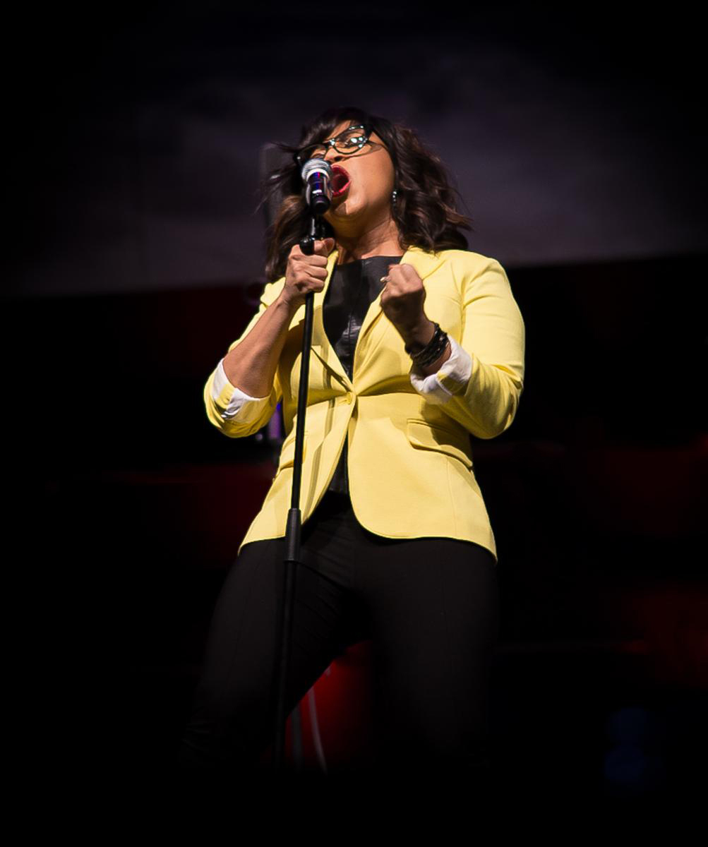 Erica Campbell performing on stage